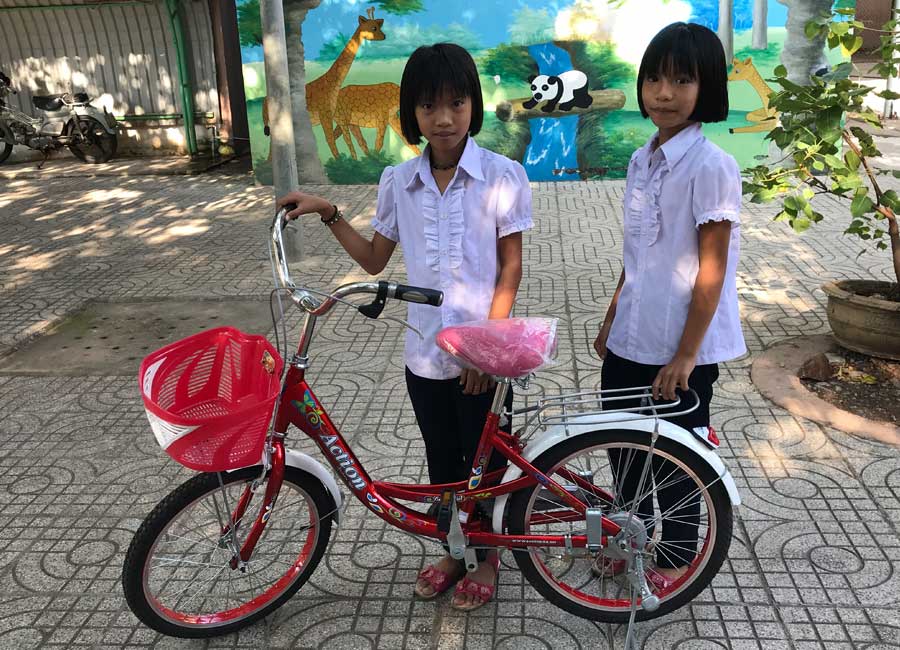 Twins Ngoc and Nga with their new bicycle.