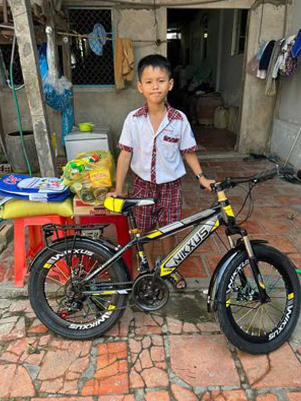 Loc with his new bicycle. Part of the donate a bike to a Vietnamese school child charity.